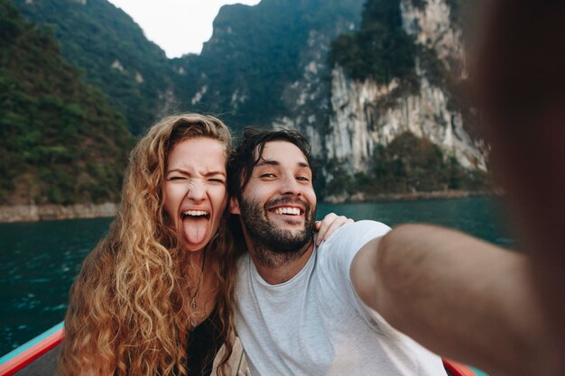 Couple prenant selfie sur un bateau longtail