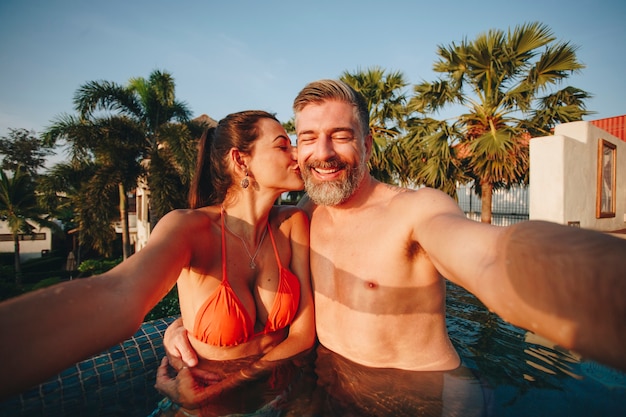 Couple prenant un selfie dans une piscine