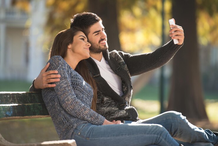 Photo couple prenant un selfie à l'extérieur dans le parc