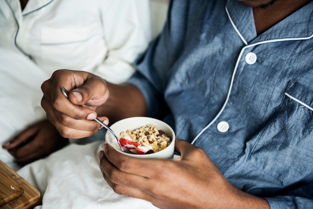 Un couple prenant son petit déjeuner au lit