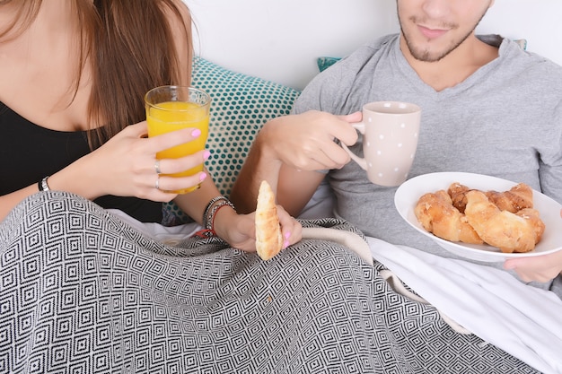 Couple prenant son petit déjeuner au lit