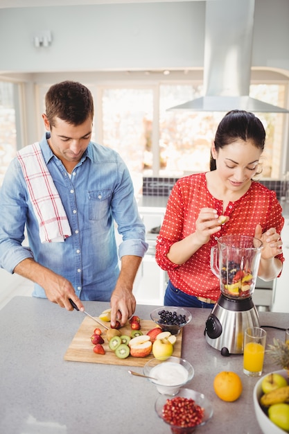 Couple préparant des jus de fruits