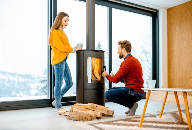 Couple près de la cheminée dans la maison moderne