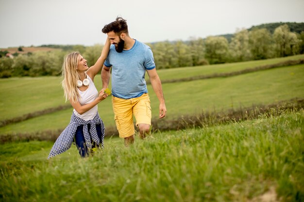 Couple profitant d&#39;une promenade à travers l&#39;herbe