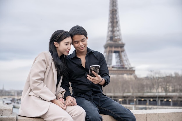 Un couple profite d'une belle vue sur Paris et la Tour Eiffel vacances en France