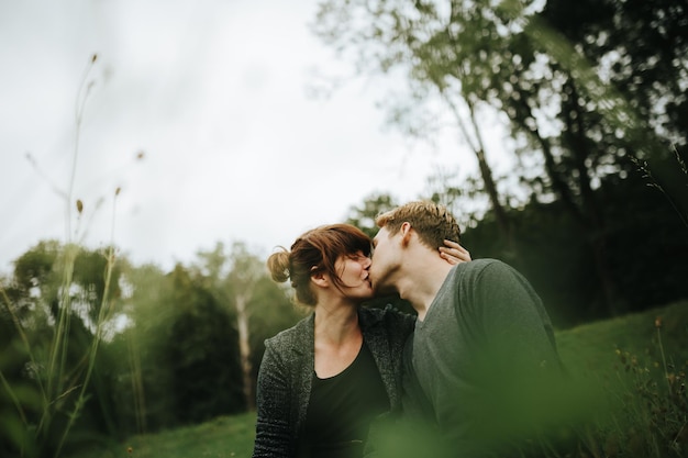 Un couple qui s'embrasse dans le parc.