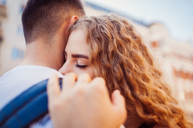 Couple de race mixte amoureux étreignant à l'extérieur. Homme arabe et femme blanche marchant en ville. Relations amoureuses