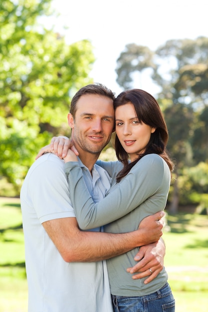 Couple radieux étreindre dans le parc