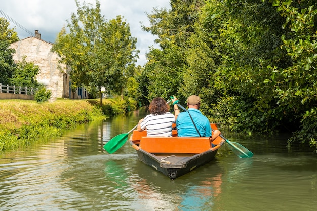 Un couple ramant le bateau naviguant entre La Garette et Coulon, Marais Poitevin la Venise Verte, près de la ville de Niort, France