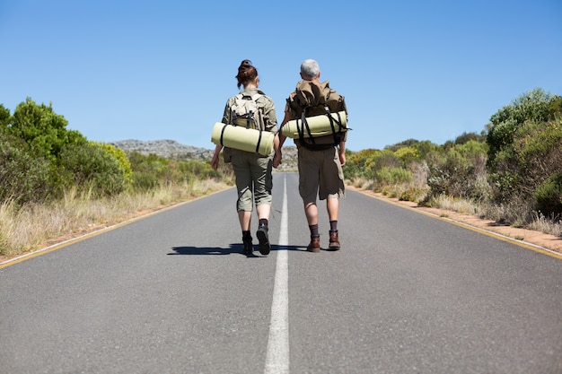 Couple de randonnée auto-stop les mains sur la route