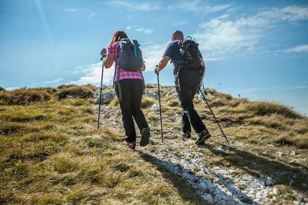 Photo couple en randonnée sur le plateau de nanos en slovénie lors d'une journée ensoleillée