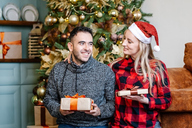 Couple ravi positif se donnant des cadeaux de Noël