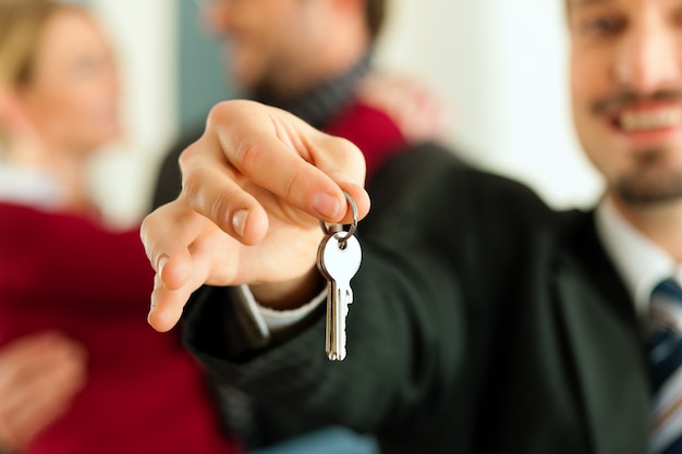 Couple recevant les clés d&#39;un courtier immobilier