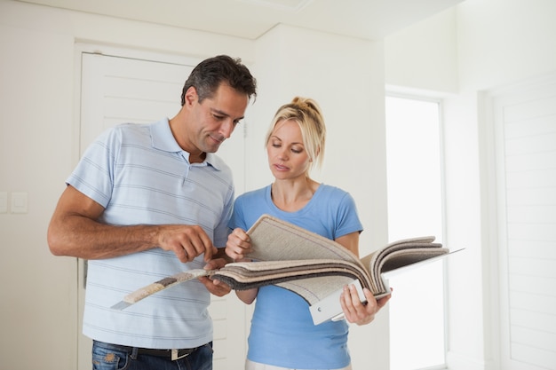 Couple regardant un livre de couleurs dans la maison