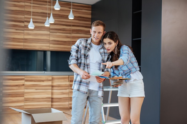 Couple regardant des palettes de couleurs avant de peindre des murs dans une nouvelle maison