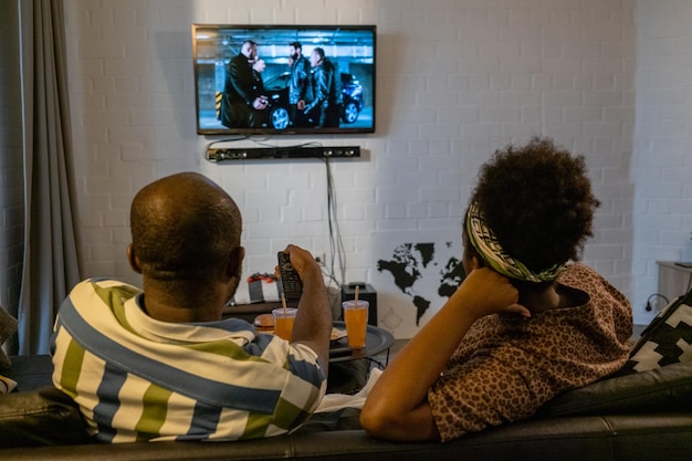 Couple regardant la télévision à la maison