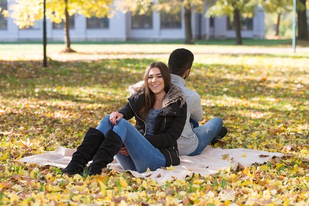 Couple Relaxing On Blanket In Autumn Park