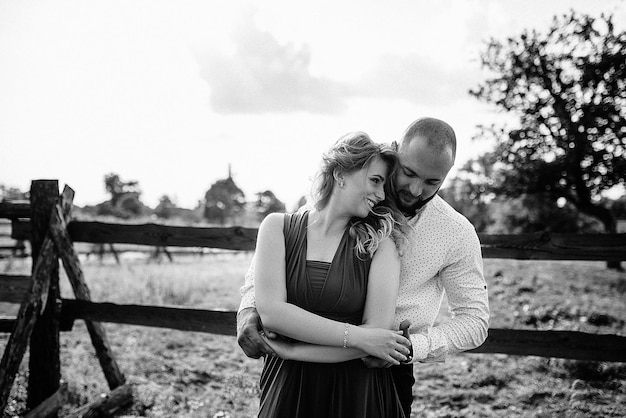 Photo couple à un rendez-vous. robe violette. mariée et marié. marcher sur le terrain. histoire d'amour. photographie en noir et blanc.