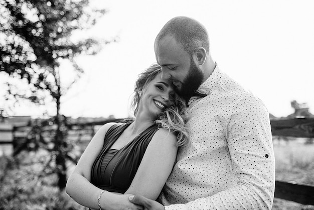 Couple à un rendez-vous. Robe violette. Mariée et marié. Marcher sur le terrain. Histoire d'amour. Photographie en noir et blanc.