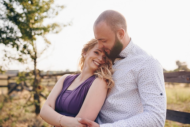 Couple à un rendez-vous. Robe violette. Mariée et marié. Marcher sur le terrain. Histoire d'amour.