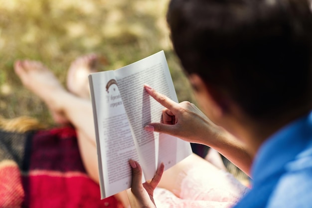 Couple à un rendez-vous romantique en plein air en lisant un livre