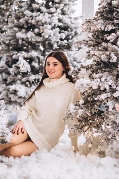 Un couple reste sur la neige dans la forêt de Noël