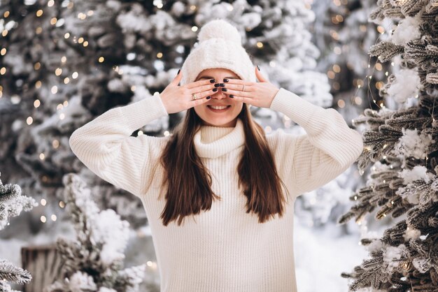 Un couple reste sur la neige dans la forêt de Noël