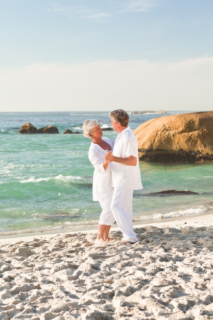 Couple de retraités dansant sur la plage