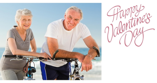 Couple de retraités avec leurs vélos sur la plage contre un joli message de la Saint-Valentin