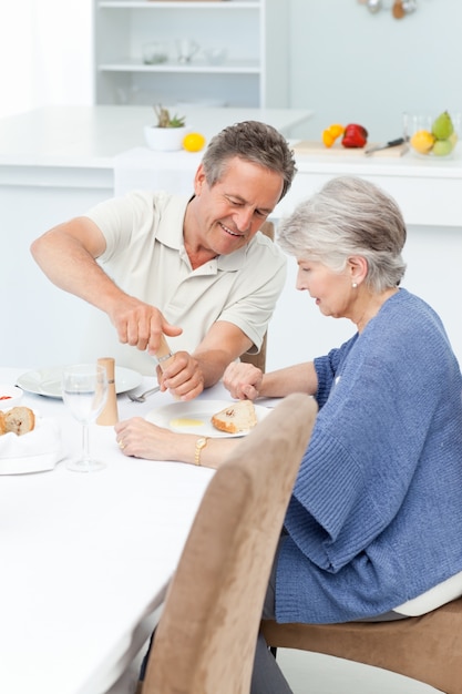 Couple de retraités mangeant dans la cuisine