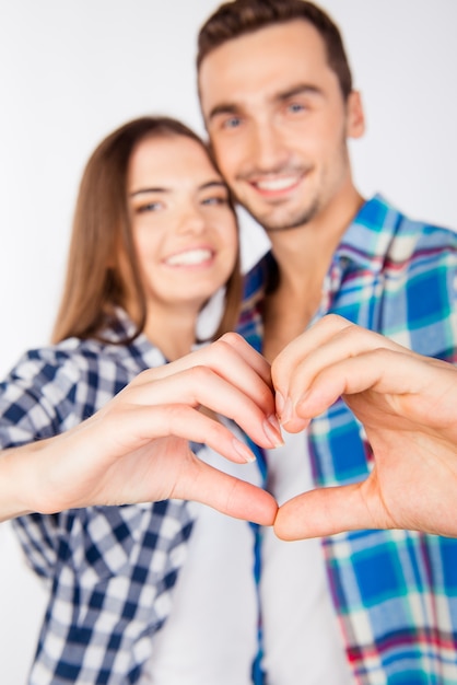 Couple romantique amoureux gesticulant un cœur avec les doigts