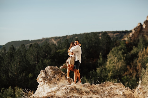 Couple romantique amoureux sont debout et embrassant sur la montagne pierreuse