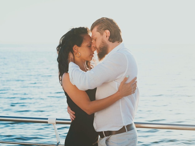 Un couple romantique dansant au bord de la mer contre le ciel