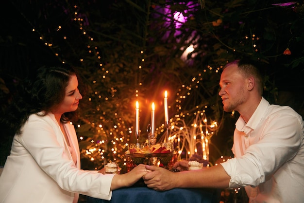 Couple romantique datant la nuit au restaurant atmosphère chaleureuse beau jeune couple avec des verres de vin rouge lors d'un dîner romantique Sweet Couple Date Dinner