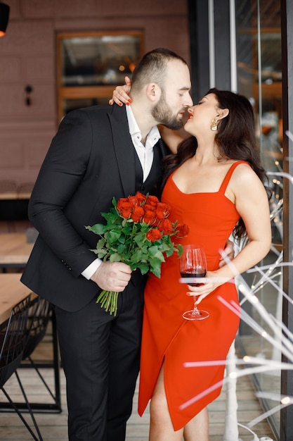 Couple romantique debout au restaurant à un rendez-vous et s'embrassant