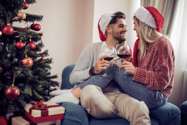 Couple romantique avec du vin rouge à la maison