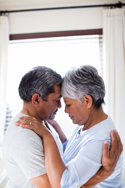 Couple romantique embrassant face à face dans la chambre