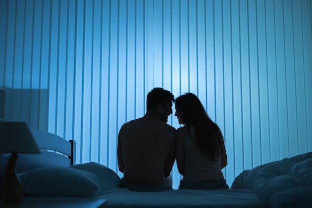 Le couple romantique est assis sur le lit. la nuit