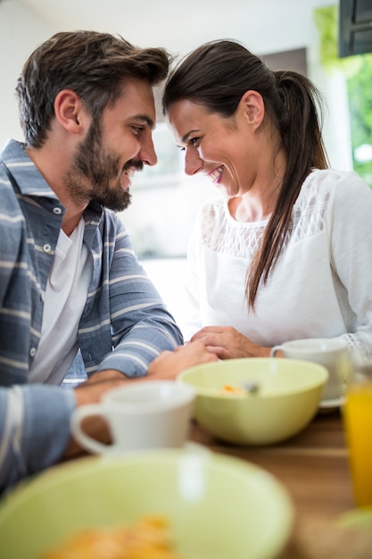 Couple romantique face à face tout en prenant son petit déjeuner