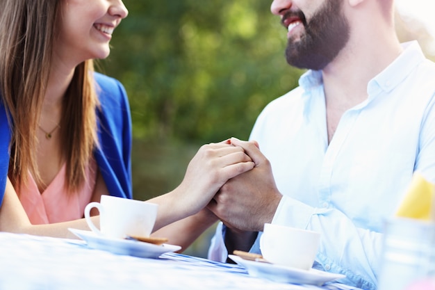 couple romantique main dans la main au café