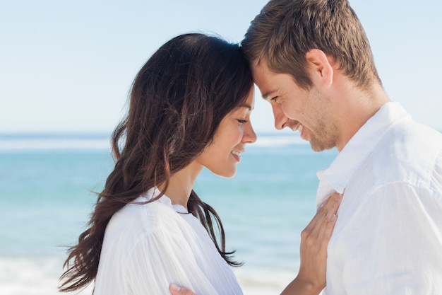 Couple romantique relaxant et embrassant sur la plage