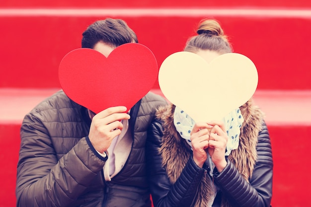 Photo couple romantique s'amusant avec des coeurs