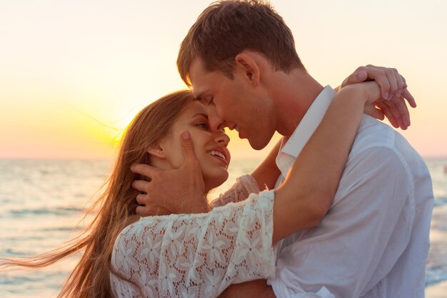 Couple romantique s'embrassant sur la plage