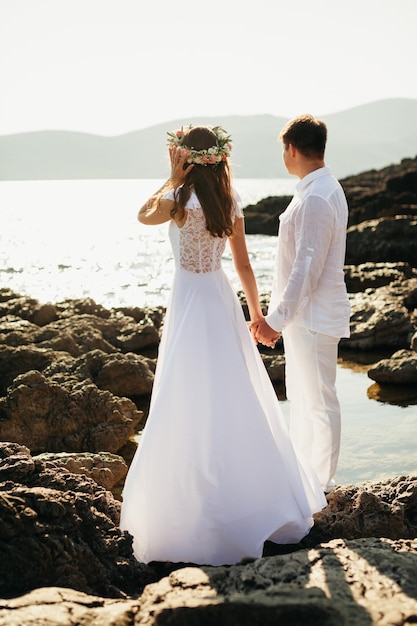 Un couple romantique se détend sur une plage rocheuse. Vue pittoresque avec montagnes et baie.