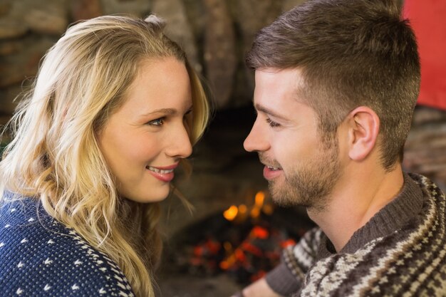 Couple romantique souriant devant la cheminée