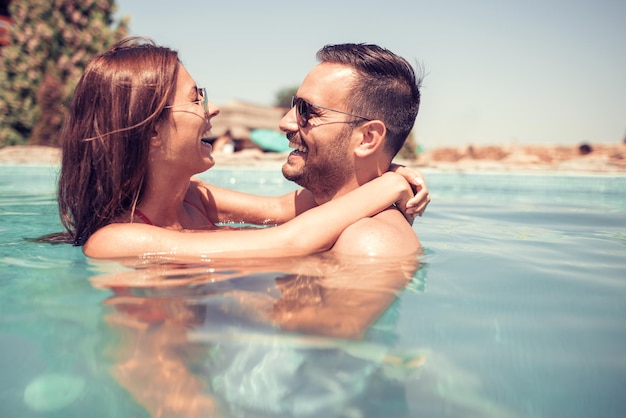 Couple s&#39;amusant dans la piscine