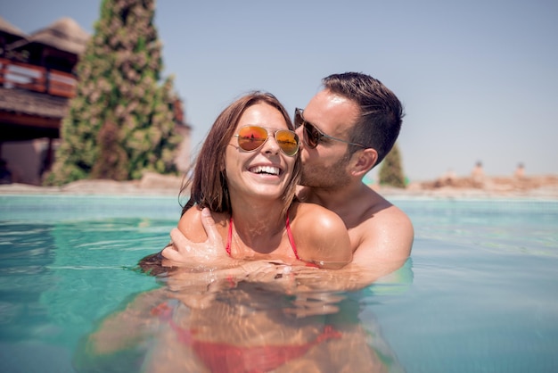 Couple s&#39;amusant dans la piscine