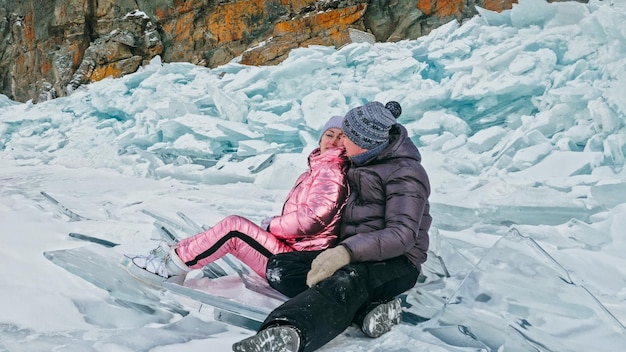 Le couple s'amuse pendant la promenade d'hiver sur fond de glace de f