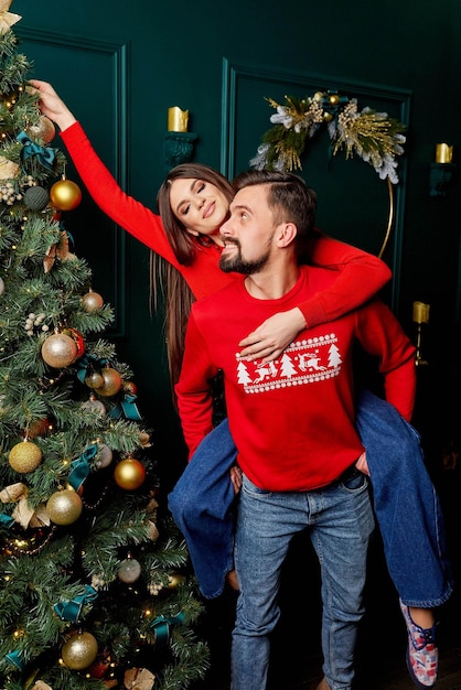 Le couple s'amuse près du sapin de Noël