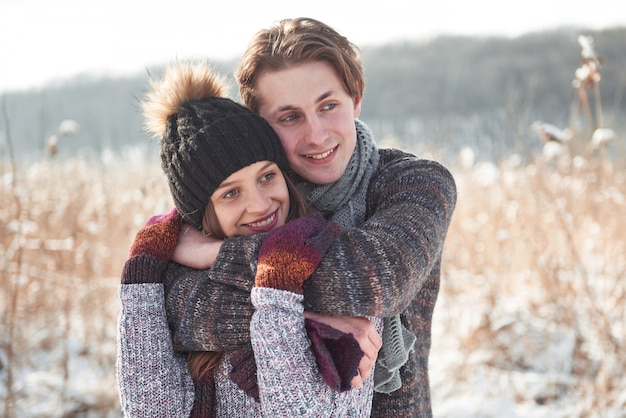 Le couple s'amuse et rit. baiser. Couple de jeunes hipster s'embrassant à winter park. Histoire d'amour d'hiver, un beau jeune couple élégant. Concept de mode d'hiver avec copain et copine